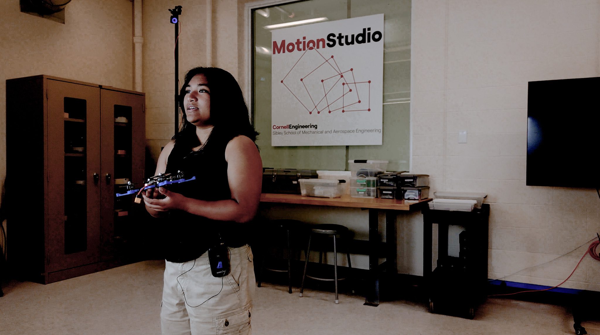 student holding drone in motion studio